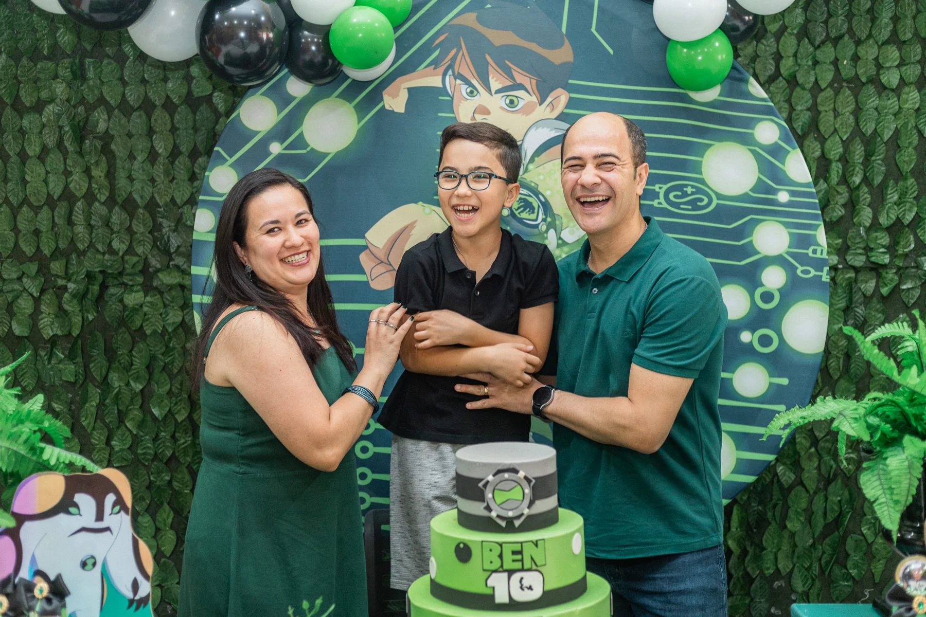 Família celebrando aniversário infantil em cenário verde
